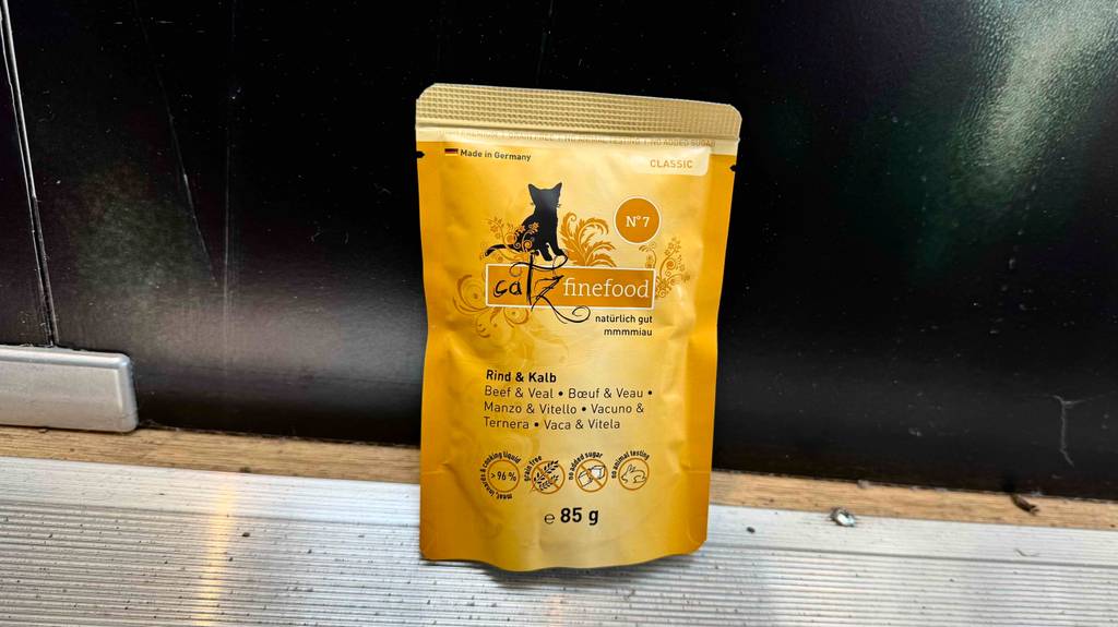 Im Test: Katzenfutter ohne Zucker und Getreide in einem wiederverschließbaren 85-g-Beutel steht vor einem schwarzen Hintergrund.
