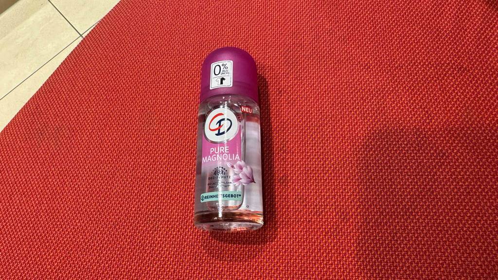 Ein Fläschchen CD-Deo liegt zum Testen auf einem roten Tuch.
