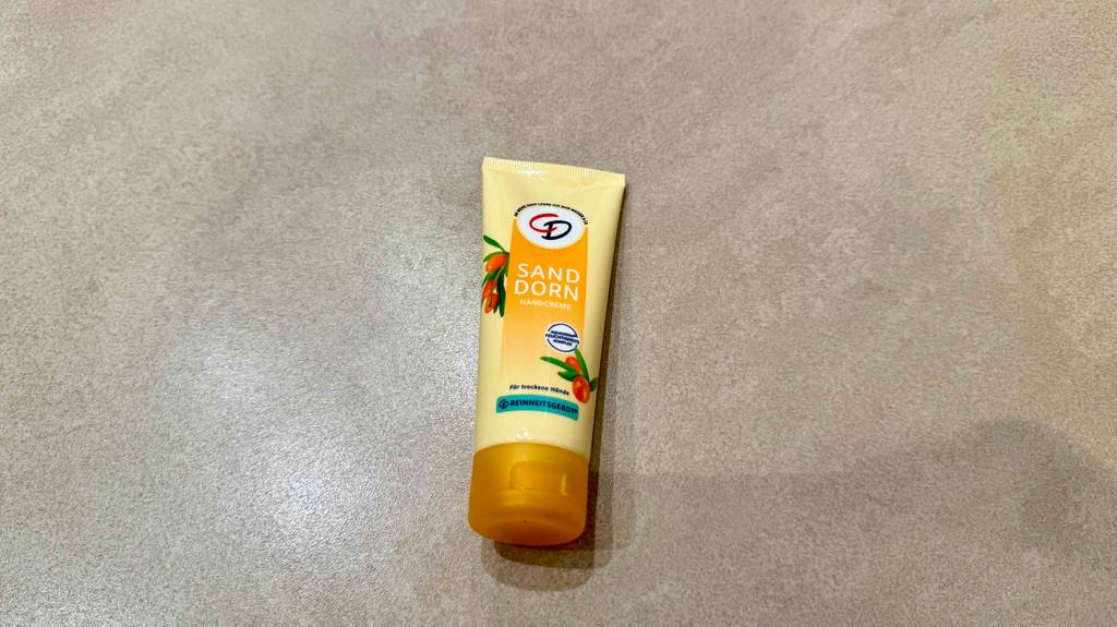 Sanddorn-Handcreme getestet: Eine Tube liegt auf einer hellen Fliese.