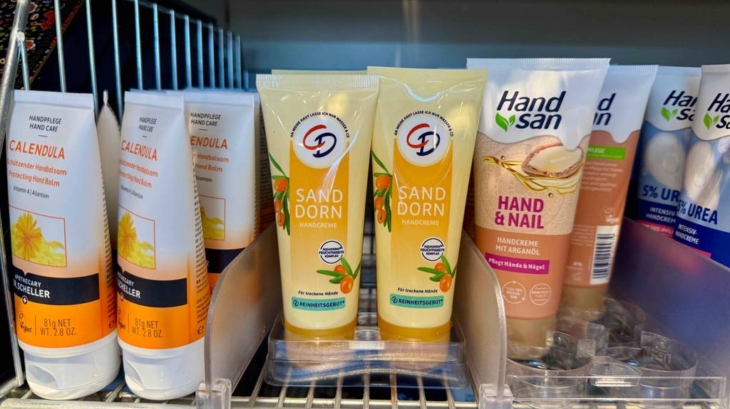 Sanddorn-Handcreme im Test: Mehrere Tuben stehen zwischen anderen Handpflegeprodukten in einem Regal.