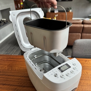 Eine Hand hält den Behälter des Cecotec Bread&Co fest