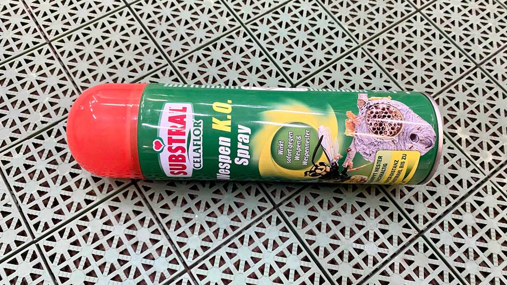 Eine liegende grüne Sprühflasche mit rotem Deckel mit Substral Celaflor Wespenspray im Test.