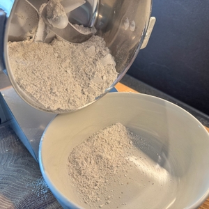 Gemahlenes Getreide wird in eine Schale gekippt