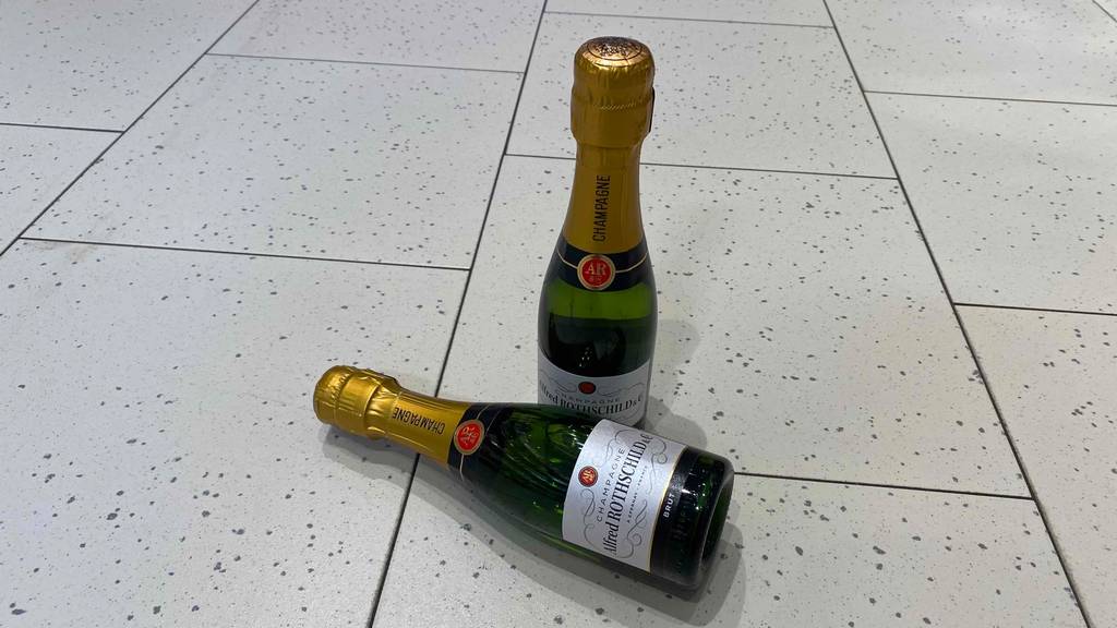 Zwei getestete Flaschen Champagner befinden sich auf dem Boden. 