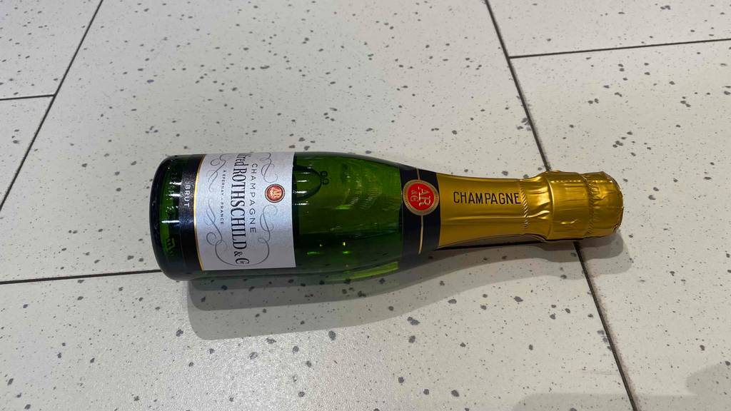 Champagner im Test: Eine Alkoholflasche liegt auf dem Boden. 