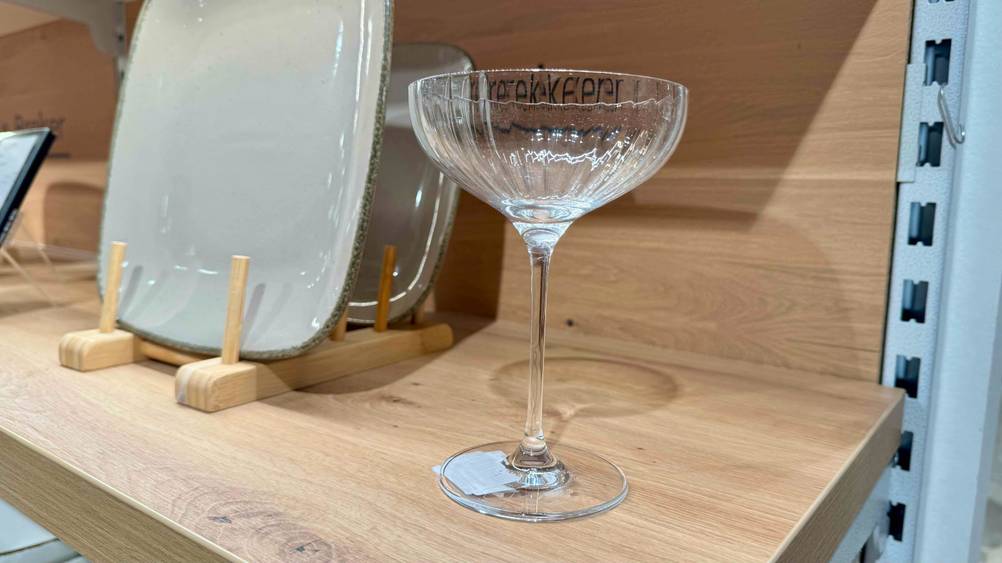 Das getestete Champagnerglas steht in einem Holzregal.