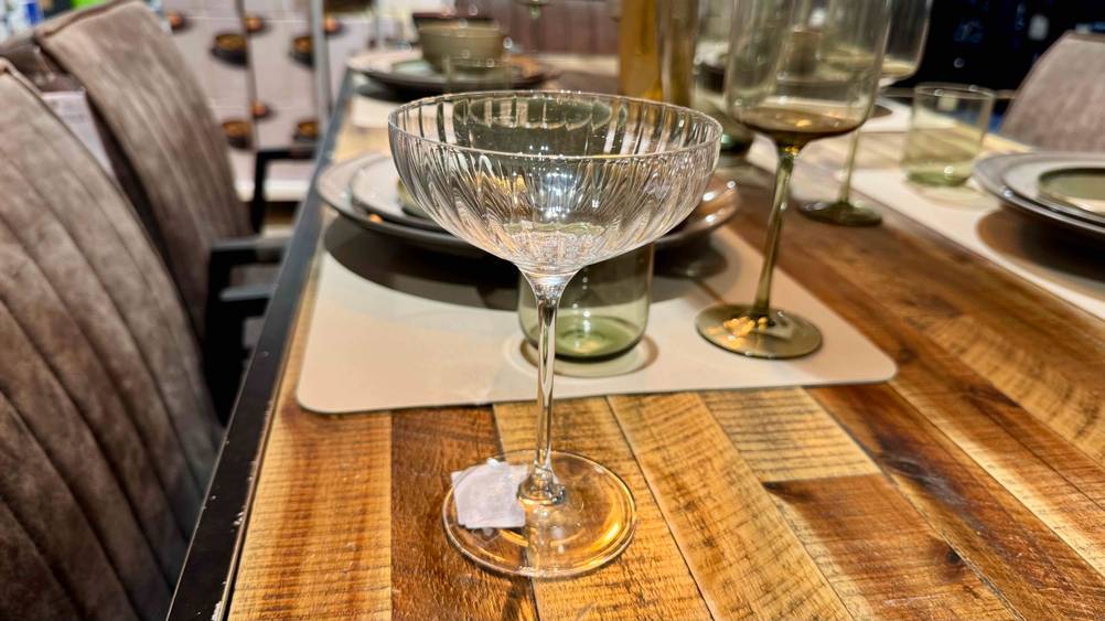 Auf einem Holztisch steht das Champagnerglas im Test.