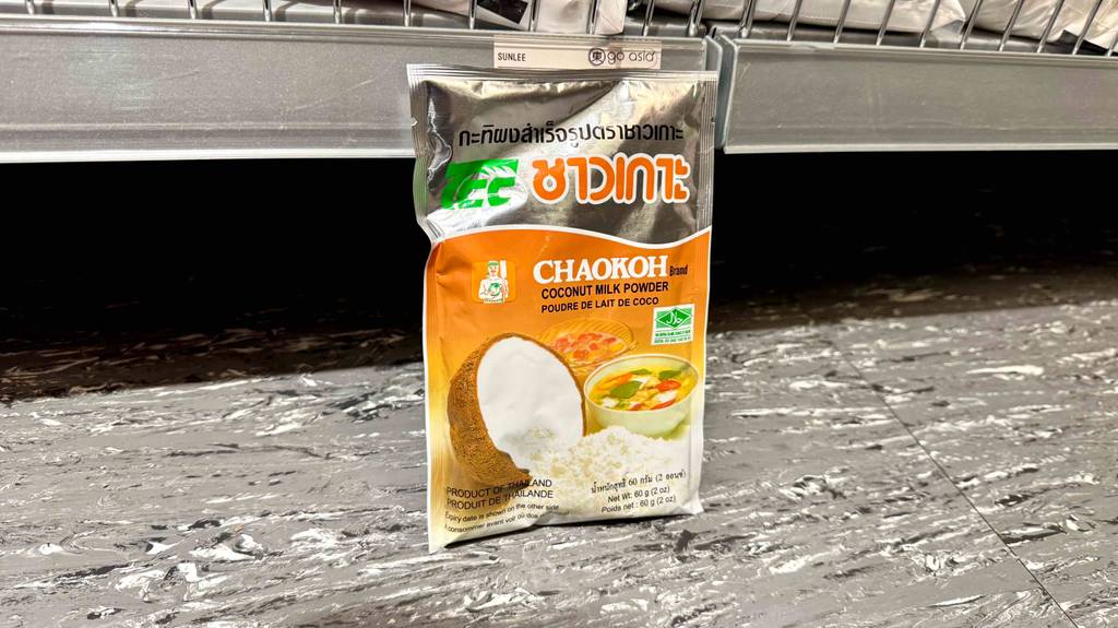 Eine Packung getestetes Kokosmilchpulver steht vor einem Regal auf einem hellen Boden.