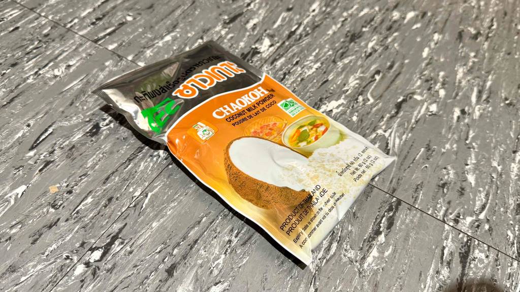 Die Verpackung von Kokosmilchpulver im Test liegt auf einem hellgrauen Boden.