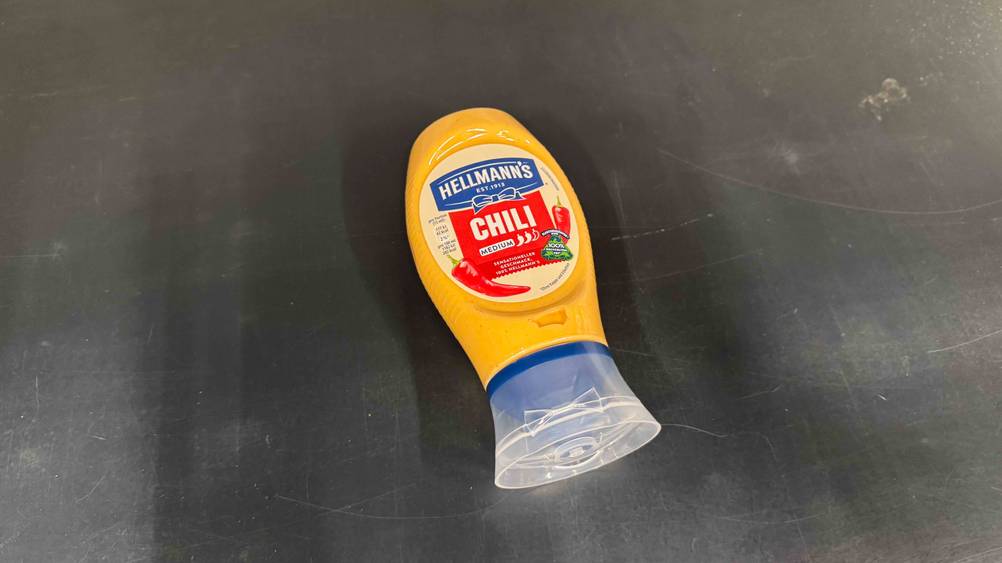 Auf einer dunklen Fläche liegt eine Flasche der getesteten Chili-Mayonnaise.