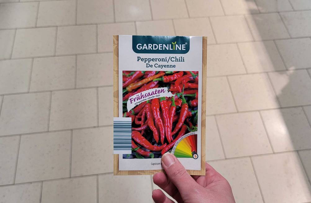 Eine Hand hält eine Packung der getesteten Chili-Samen.