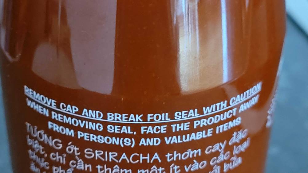 Chili-Sauce getestet: Nahaufnahme des Aufdrucks auf der Rückseite einer Flasche.