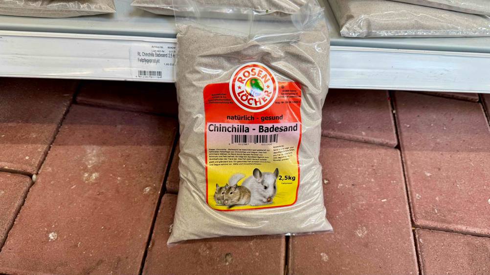 Vor einem Regal auf dem Boden steht eine Packung des getesteten Chinchillasand.