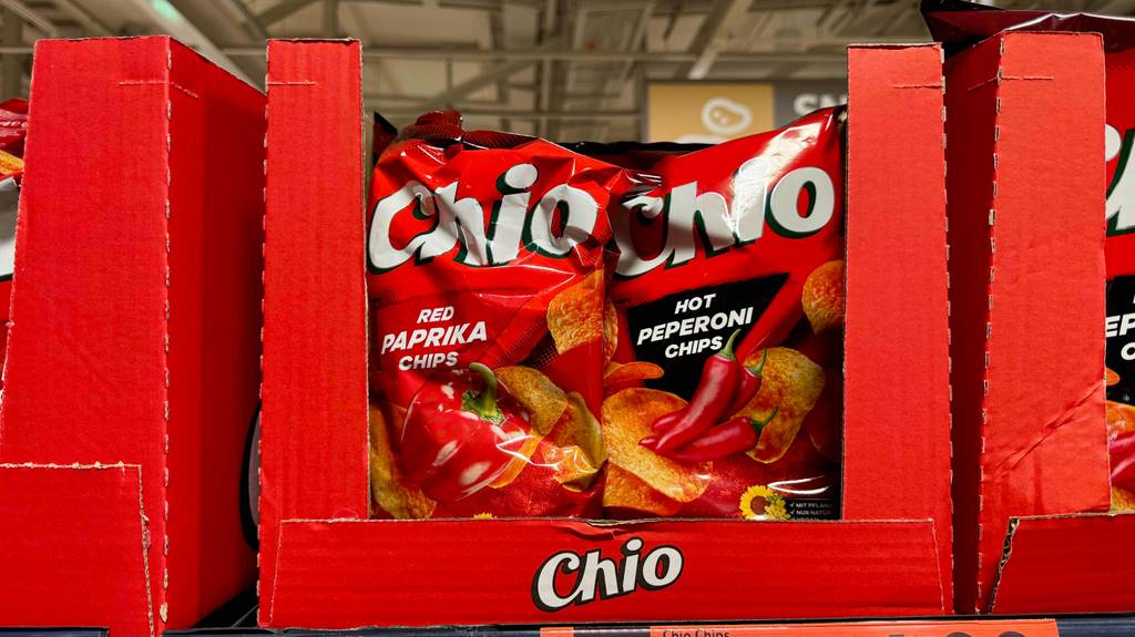 Mehrere Tüten von Chio mit Paprika-Chips im Test stehen in einem Verkaufskarton auf dem Regal.