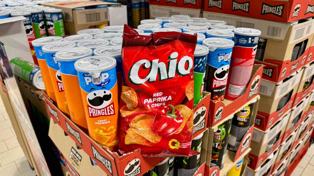 Eine Tüte von Chio mit getesteten Paprika-Chips steht vor Chips-Packungen anderer Marken.