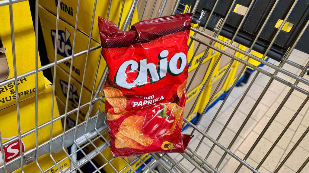 Eine rote Tüte von Chio mit getesteten Paprika-Chips liegt in einem Einkaufswagen.