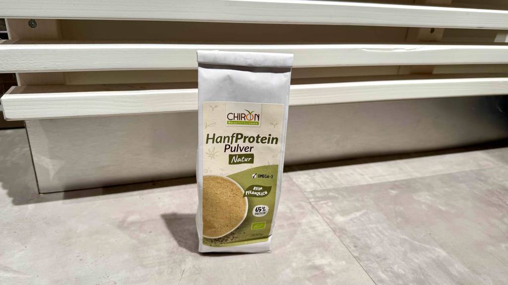 Eine Packung getestetes Bio-Hanfprotein steht vor einem weißen Regal.