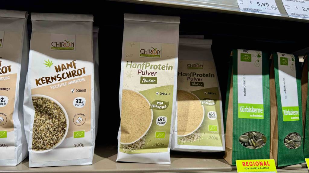 Bio-Hanfprotein im Test: Mehrere Packungen stehen zwischen anderen Produkten in einem Regal.