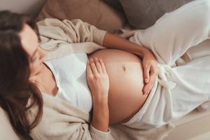 Chitosan-Test: Eine schwangere Frau fasst sich an Ihren nackten Bauch. 