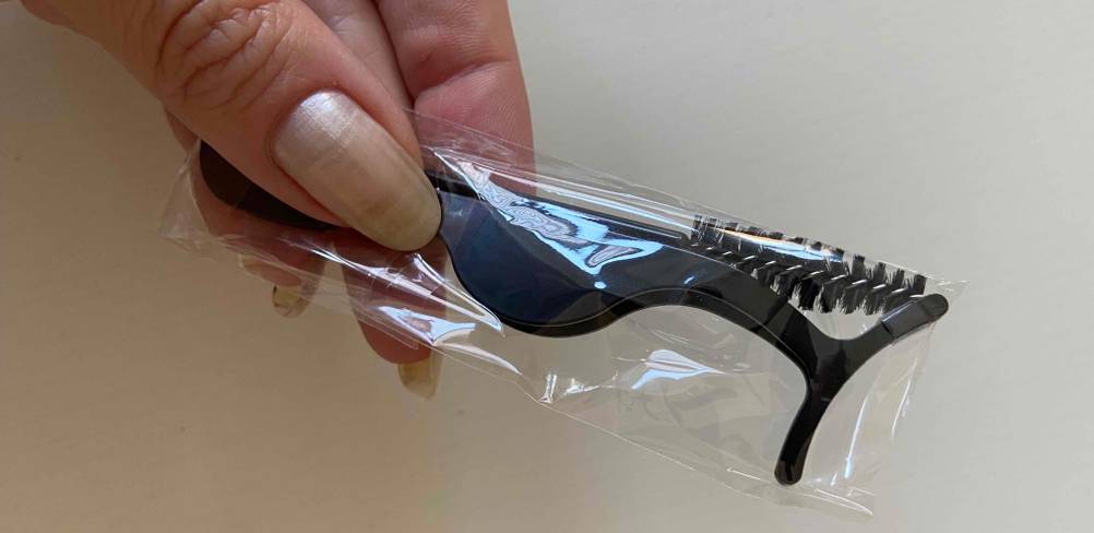 Hand hält original verpacktes Zubehör von magnetischen Wimpern im Test vor hellem Hintergrund.