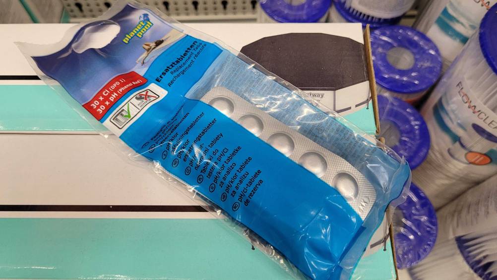 Auf einem Karton liegt eine Packung der Chlortabletten (Pool) im Test.