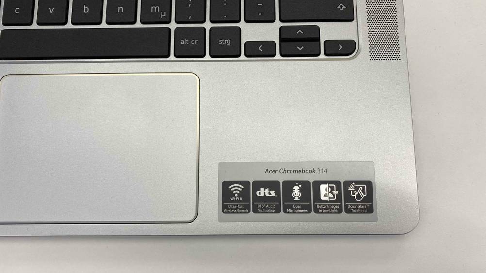 Nahaufnahme eines Aufklebers mit Infografiken neben dem Trackpad eines Chromebooks im Test.