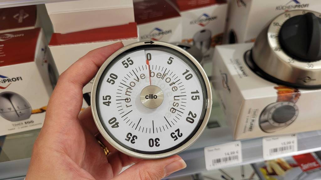 Eine Hand hält einen mechanischen Kurzzeitwecker zum Testen.