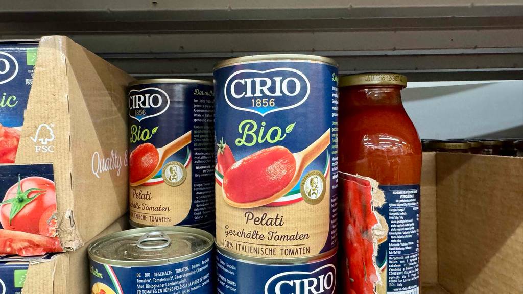 Mehrere Dosen Bio-Tomatensauce stehen zum Testen mit anderen Produkten in einem Regal.