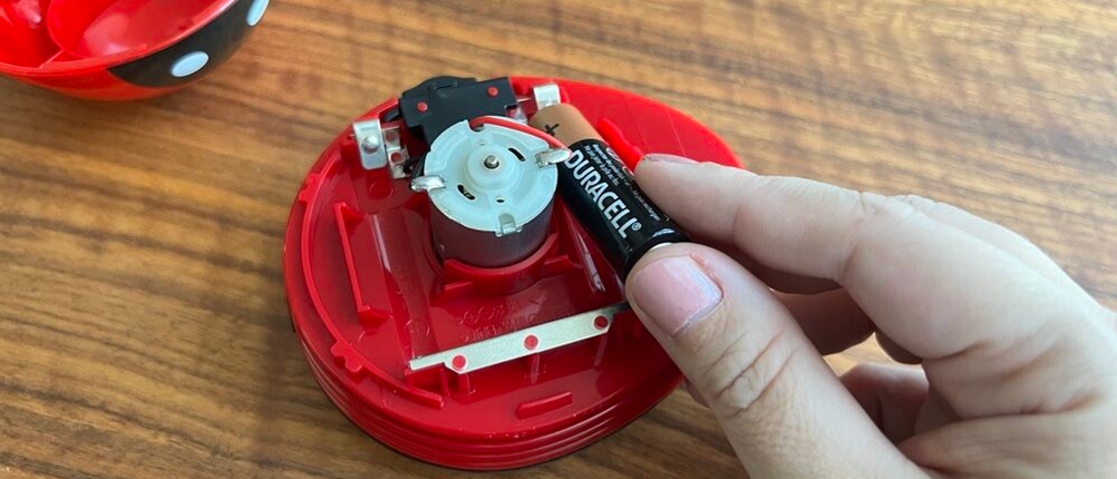 Batterien werden in den geöffneten Tischstaubsauger gesetzt.