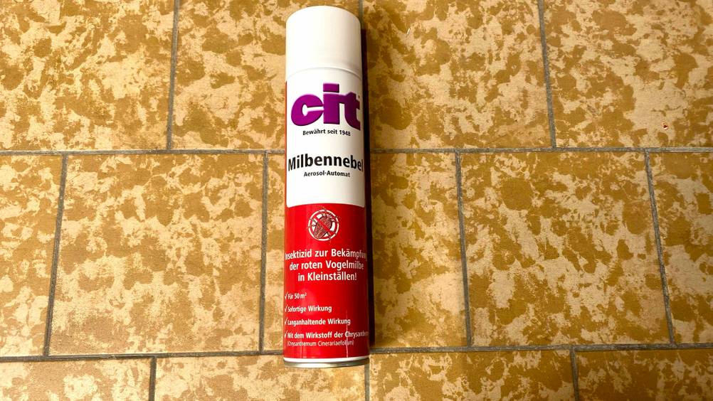 Im Test: Eine Dose Milbenspray liegt auf einer gelben Fließenfläche.