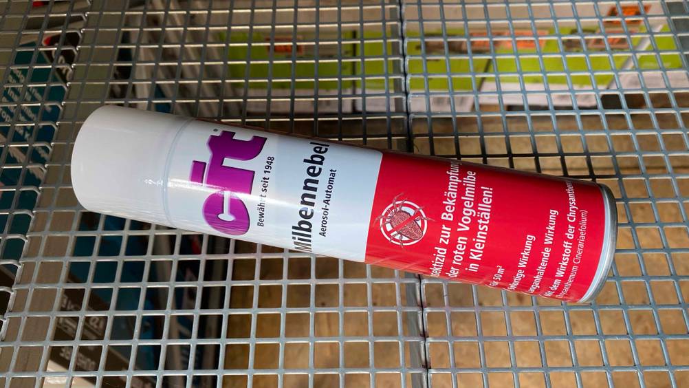 Eine Dose getestetes Milbenspray auf einem Gitter liegend.
