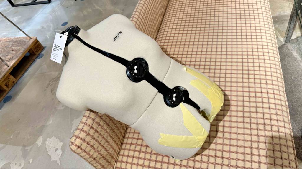 Eine Schneiderpuppe verstellbar liegt zum Testen auf einem Sofa.
