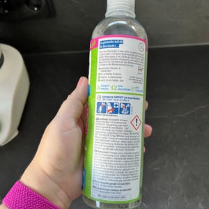 Eine Hand hält den Claro-Öko-Klarspüler so, dass man die Bedienungsanleitung lesen kann