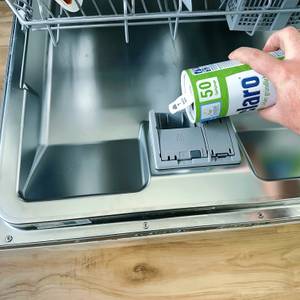 Aus der Dose des Claro-Spülmaschinenpulvers wird Pulver in die Maschine gegeben.