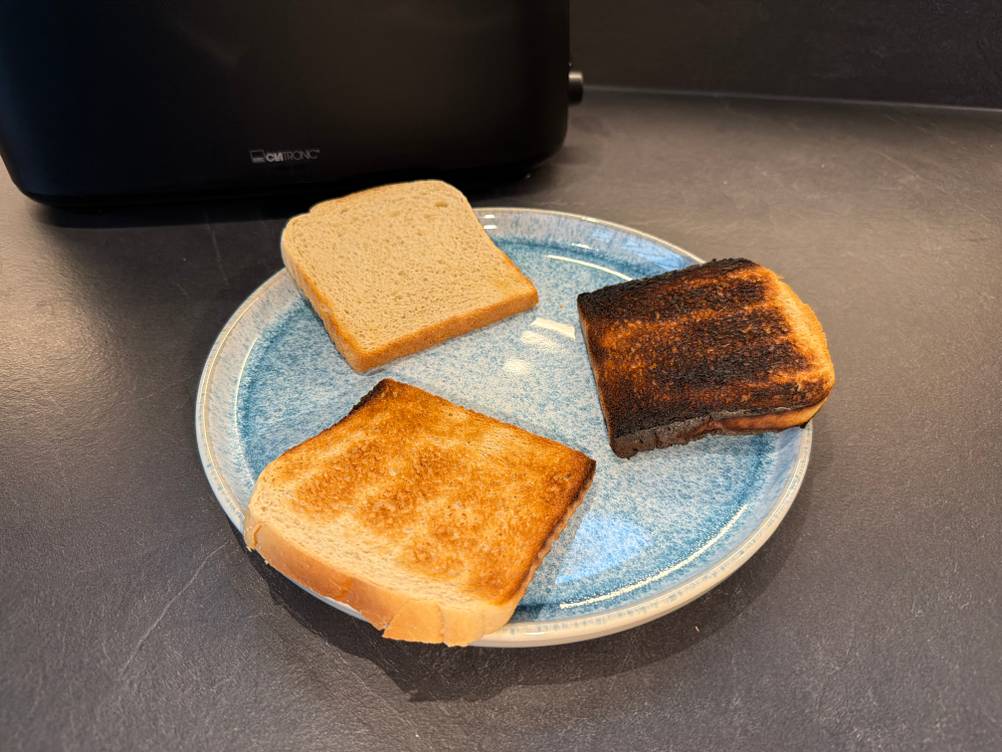 Drei unterschiedlich stark mit dem Clatronic-Langschlitztoaster getoastete Toastscheiben liegen auf einem Teller