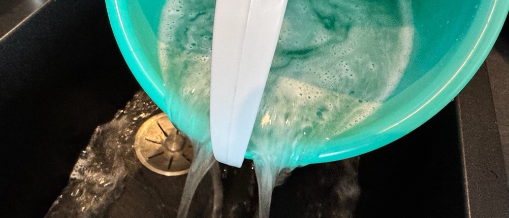 Wasser wird aus dem Behälter des Cleanmaxx 05549 gekippt.