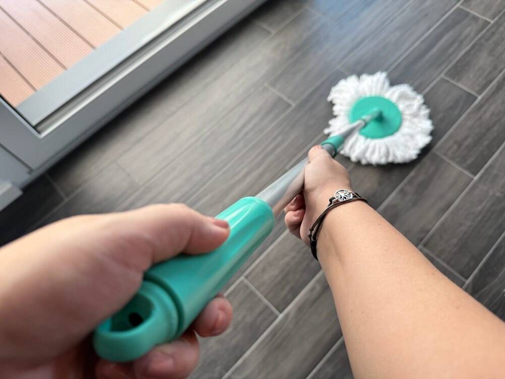 Zwei Hände reinigen einen Fliesenboden mithilfe des Cleanmaxx 05549.