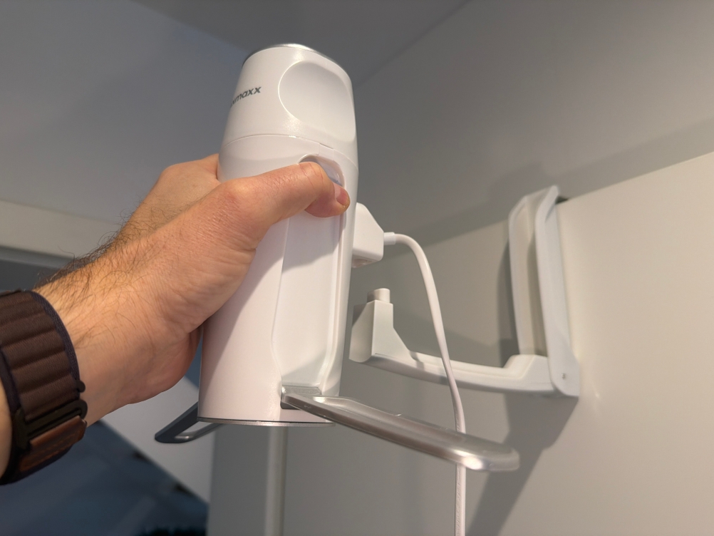 Eine Hand steckt die Cleanmaxx Pro Kompakt auf ihren Bügel