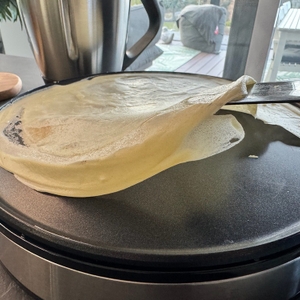 Mithilfe eines Teigschabers wird ein Crêpe auf dem Cloer 6630 angehoben