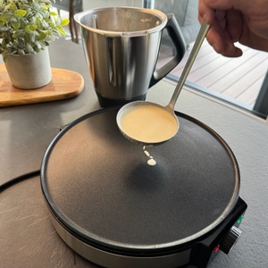 Eine Hand gibt Teig aus einer Suppenkelle auf den Cloer 6630