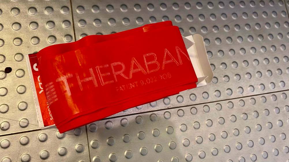 Thera-Band getestet: Ein Band mit Einprägung auf einer Metallfläche.