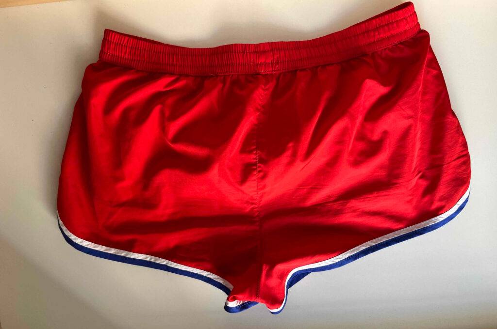 Eine rote getestete Badehose, von hinten betrachtet, liegt auf einer weißen Oberfläche.