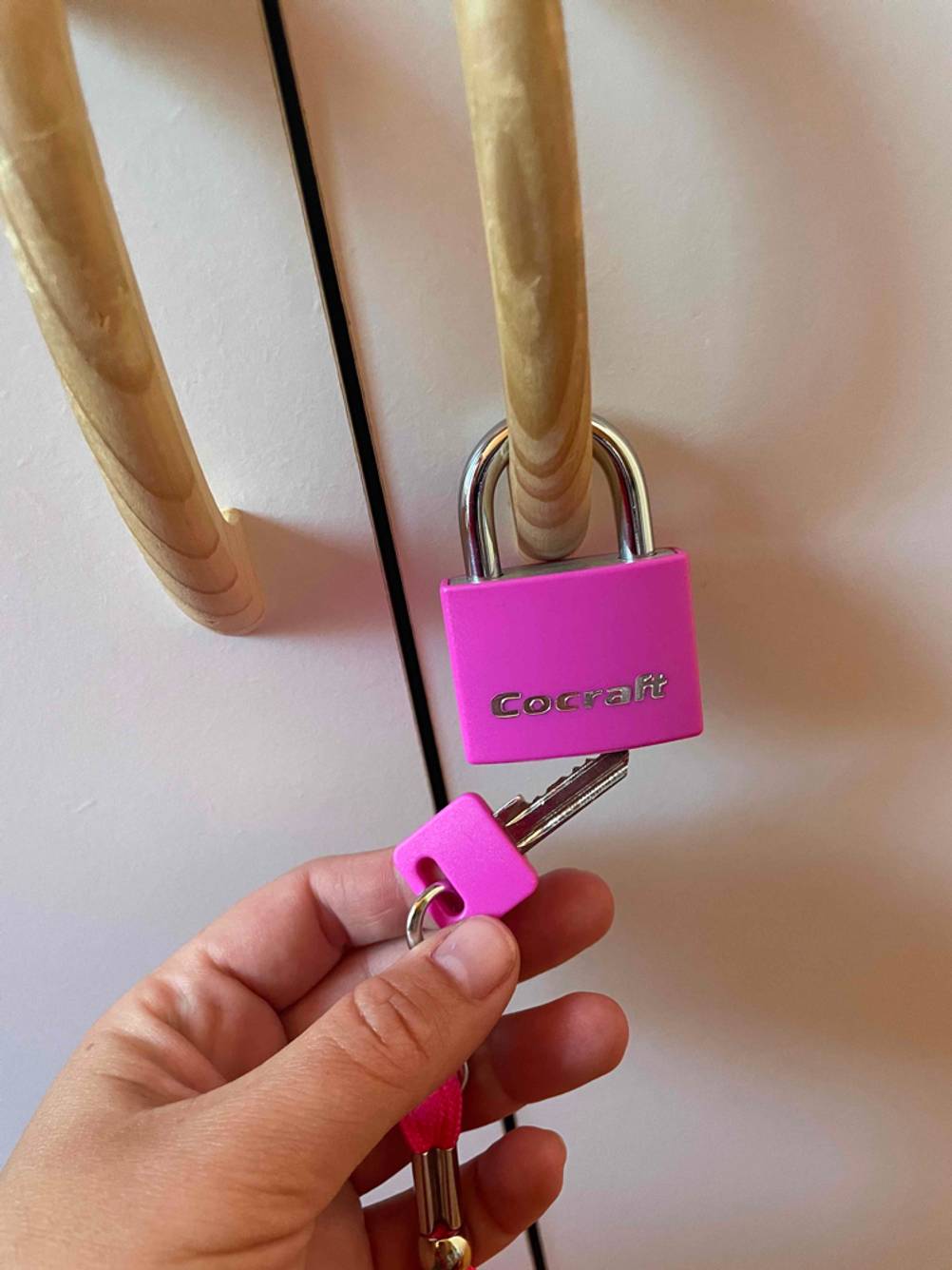 Schlüssel wird an geschlossenes Vorhängeschloss gehalten.