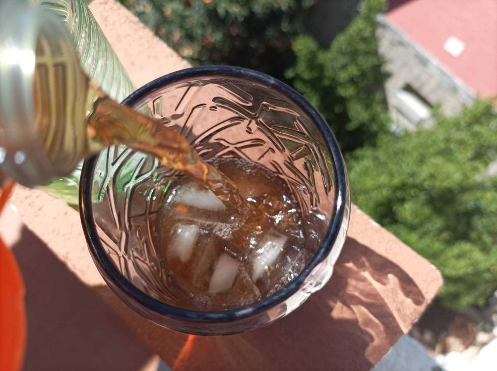 In ein Cola-Glas im Test wird von oben Flüssigkeit eingefüllt.