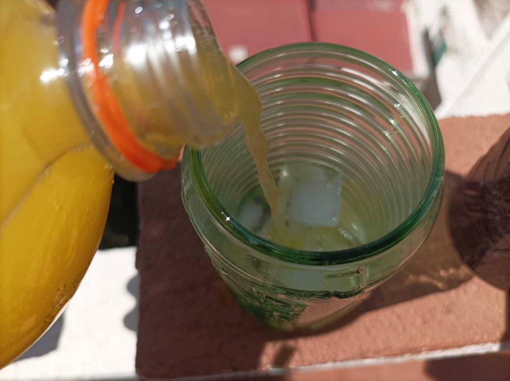 Ein Cola-Glas im Test von oben, es wird ein Getränk eingefüllt.