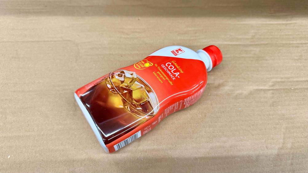 Cola-Sirup im Test: Eine Flasche liegt leicht horizontal auf einem Karton.