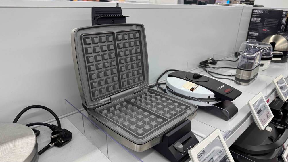 Cloer-Waffeleisen im Test: Das geöffnete Gerät auf einem Verkaufsregal neben anderen Geräten.