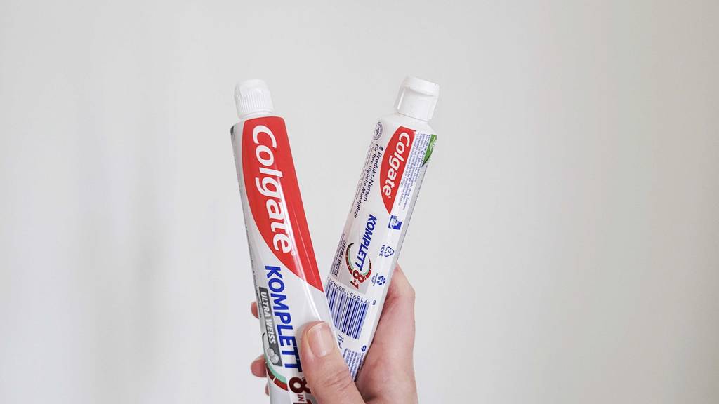 Colgate-Zahnpasta im Test: Eine Hand hält zwei Tuben.