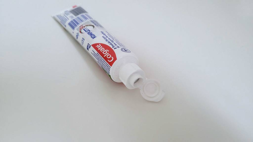 Colgate-Zahnpasta-Test: Ein Tube liegt mit offenem Deckel auf einer weißen Fläche.