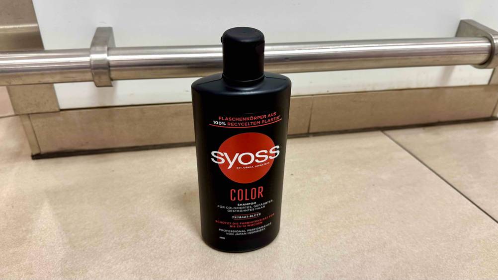 Auf einem beigen Fließenboden steht eine Flasche des Color-Shampoos im Test.
